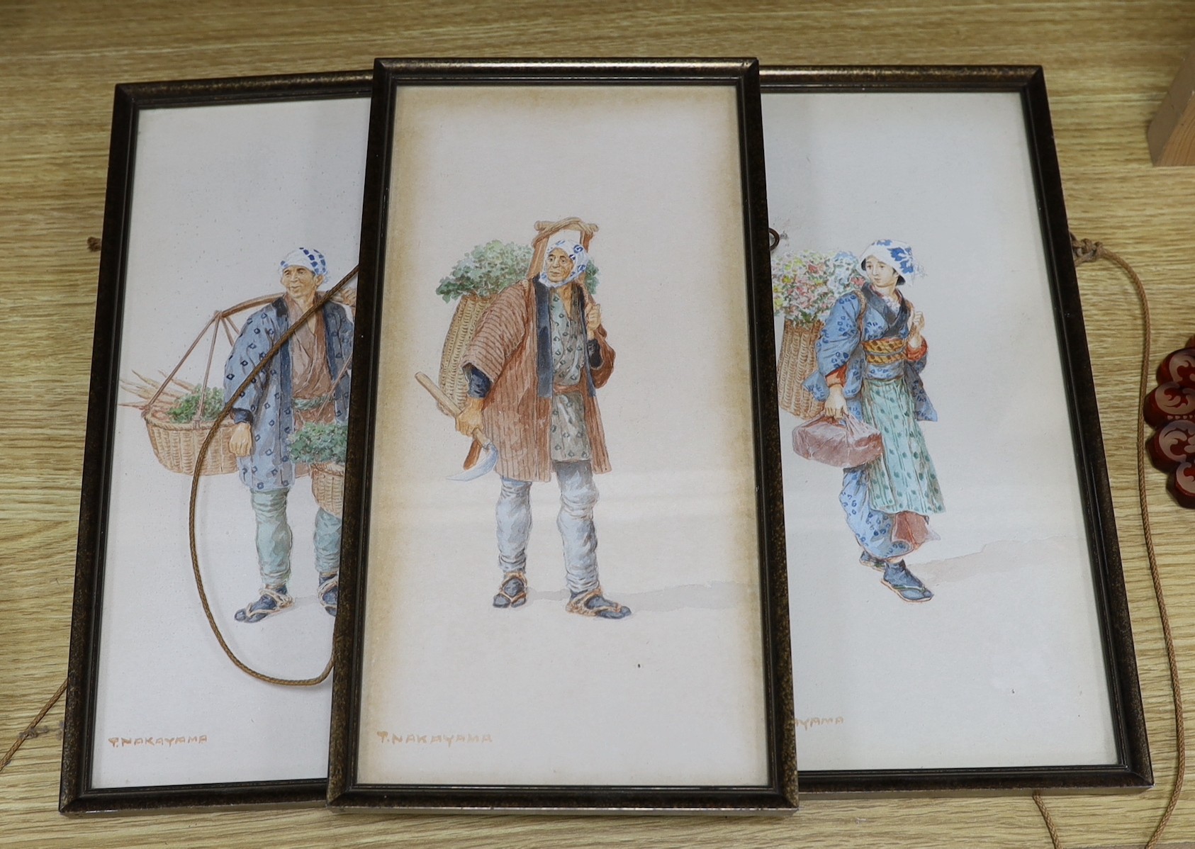Takashi Nakayama (Japanese, 1893-1978), three watercolours, Studies of peasants carrying baskets of flowers and vegetables, signed, 33 x 16cm
